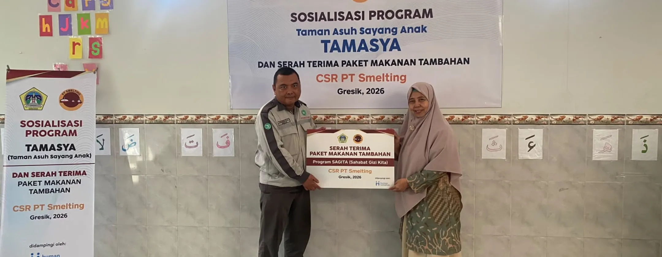 Representatives from PT Smelting management, M. Fuad as Assistant Manager of General Affairs give the donation